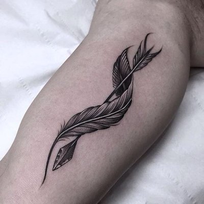 Tatouage plume qui entoure une flèche sur le haut du bras